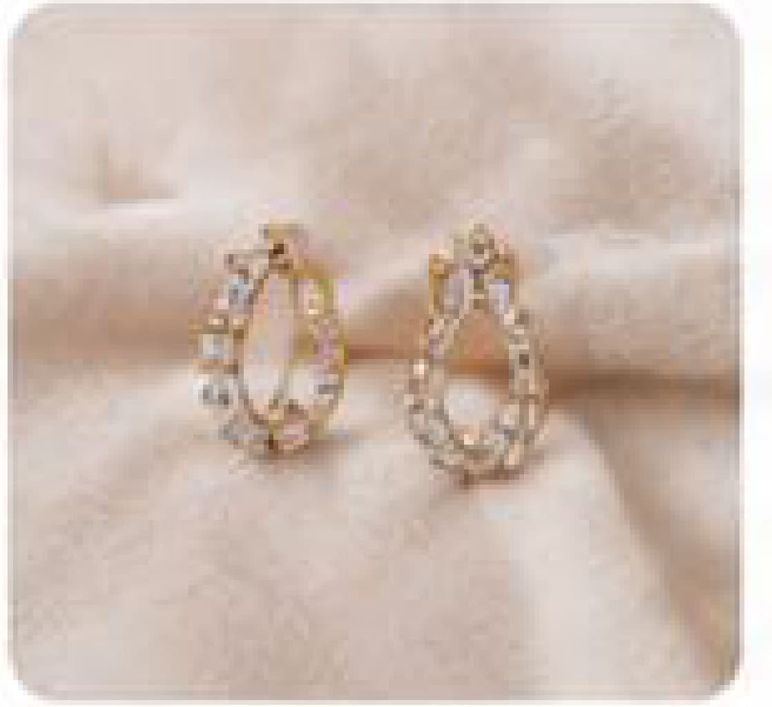 A pair of diamond teardrop hoops on linen