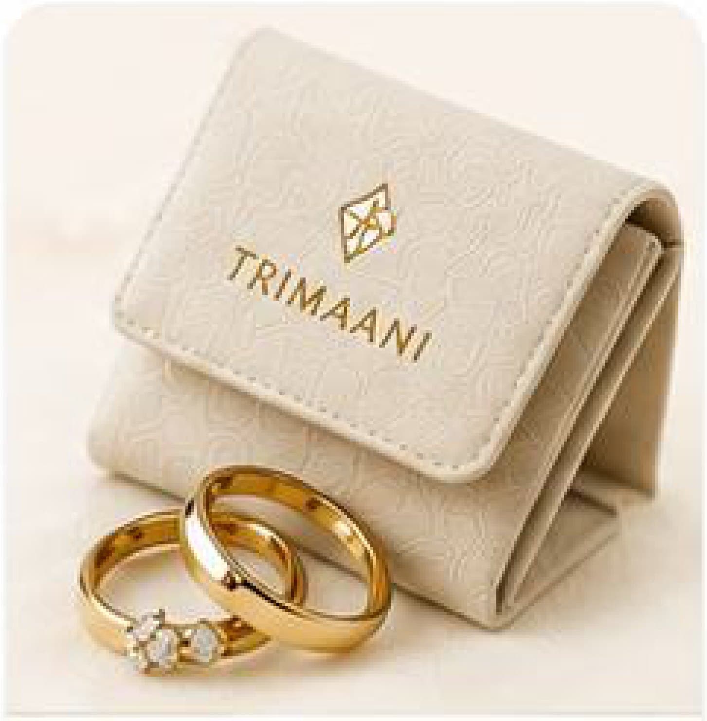 A Trimaani jewellery pouch beside two gold bands