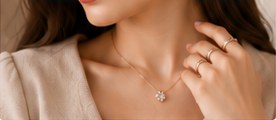 A woman wearing a fine gold chain with a floral diamond pendant