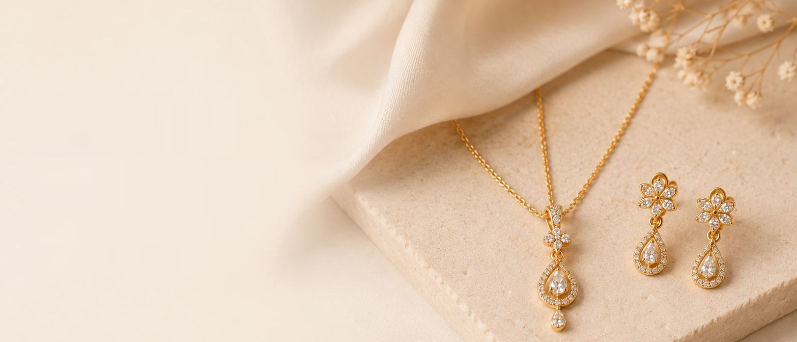 A Trimaani pendant and earrings on cream silk