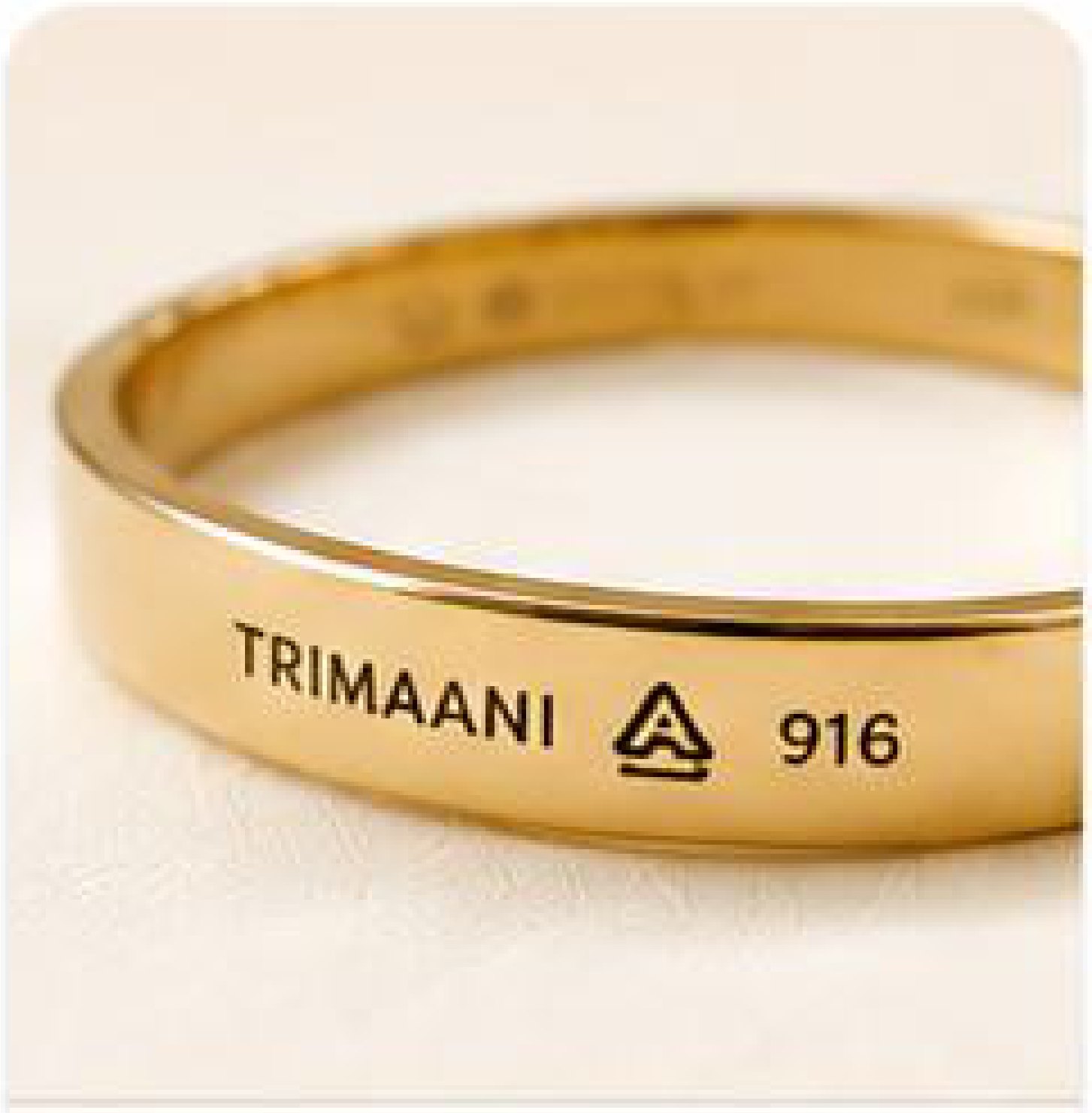 A gold band stamped with the Trimaani mark, the BIS hallmark and 916 purity