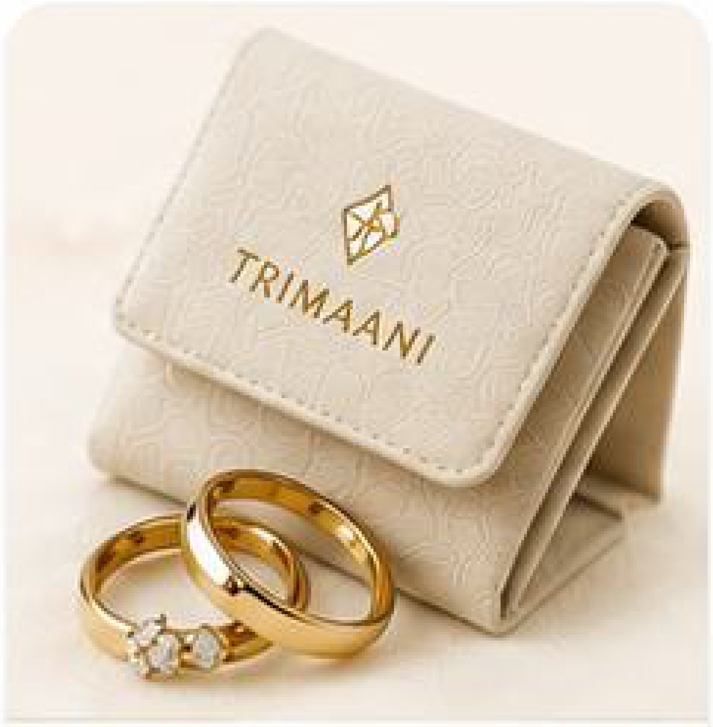 A Trimaani jewellery pouch beside two gold bands